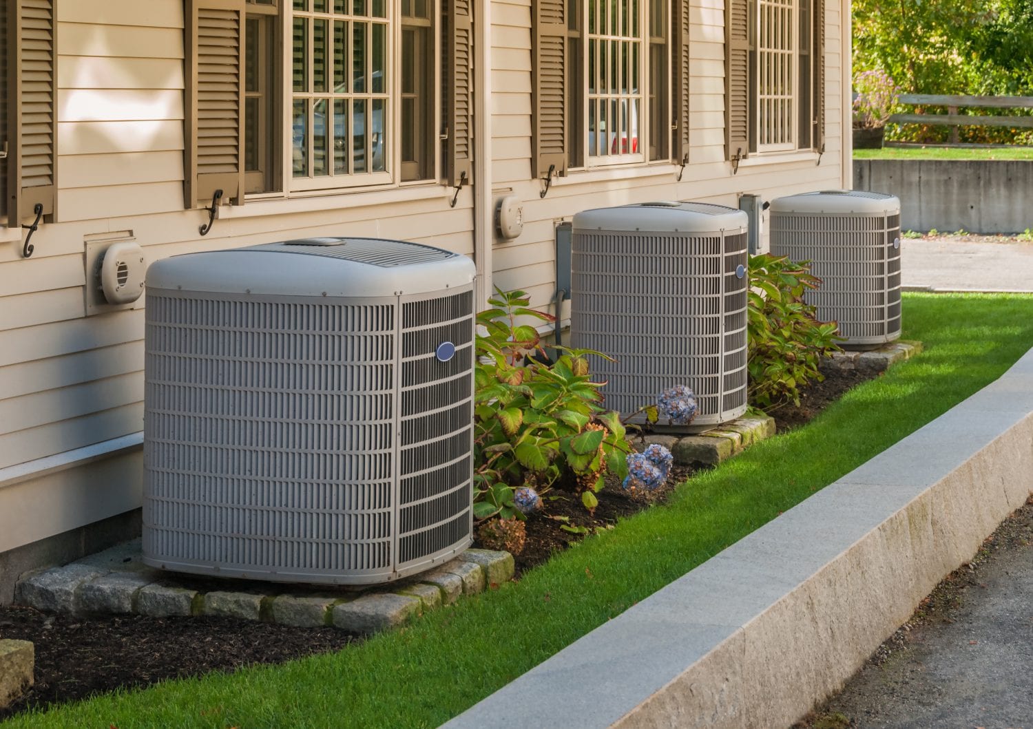 Three ac units outside of a home.